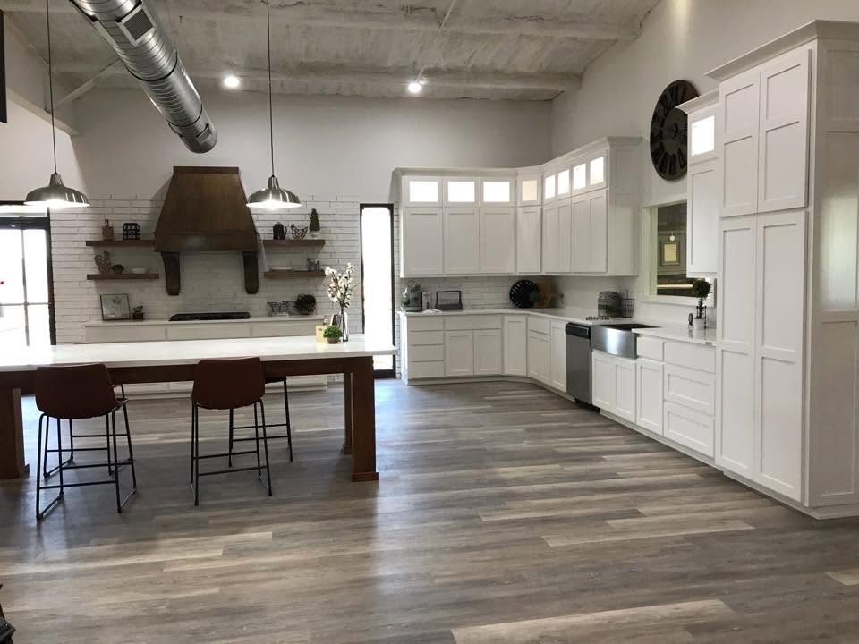Custom white kitchen cabinetry with a large center island and warm wood accents built by Latham Cabinets Inc.